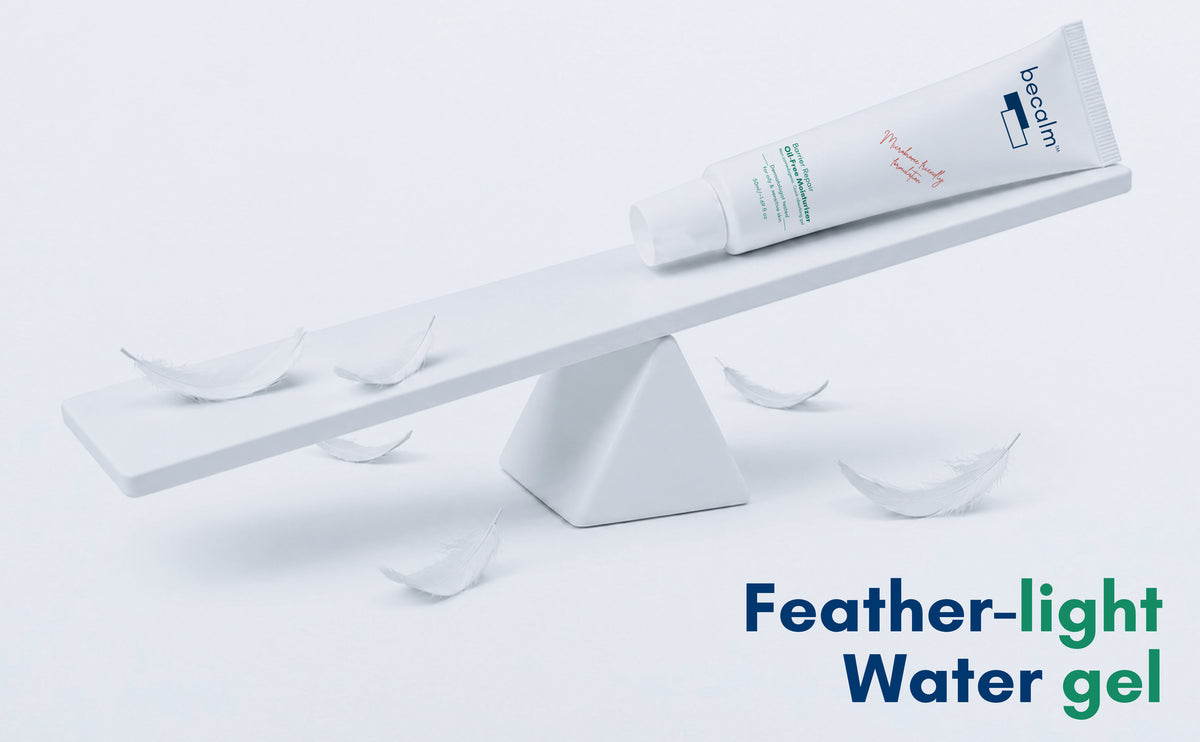 A white tube of becalm barrier repair oil free moisturizer with blue and green text lies on a white balance scale against a white background, with several feather-shaped pieces scattered around and the text 'Feather-light Water gel' in the lower right.